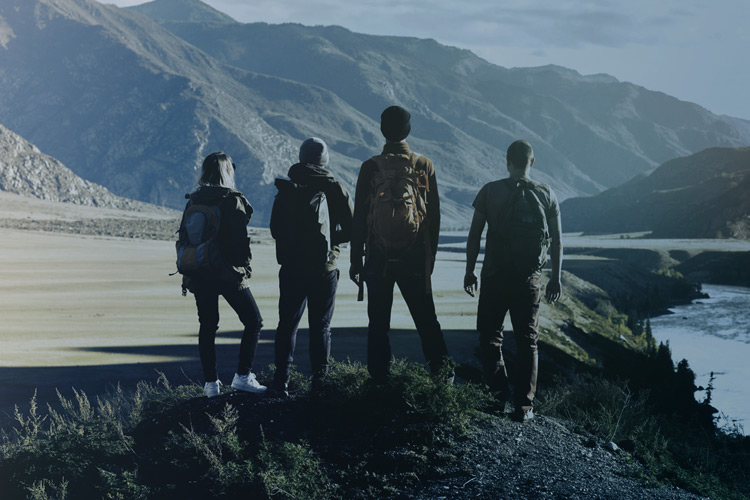 Four People Standing in Mountain Landscape