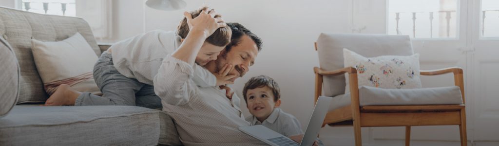 Dad Working on Laptop with Kids