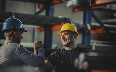 Two Workers Wearing Hardhats Shaking Hands