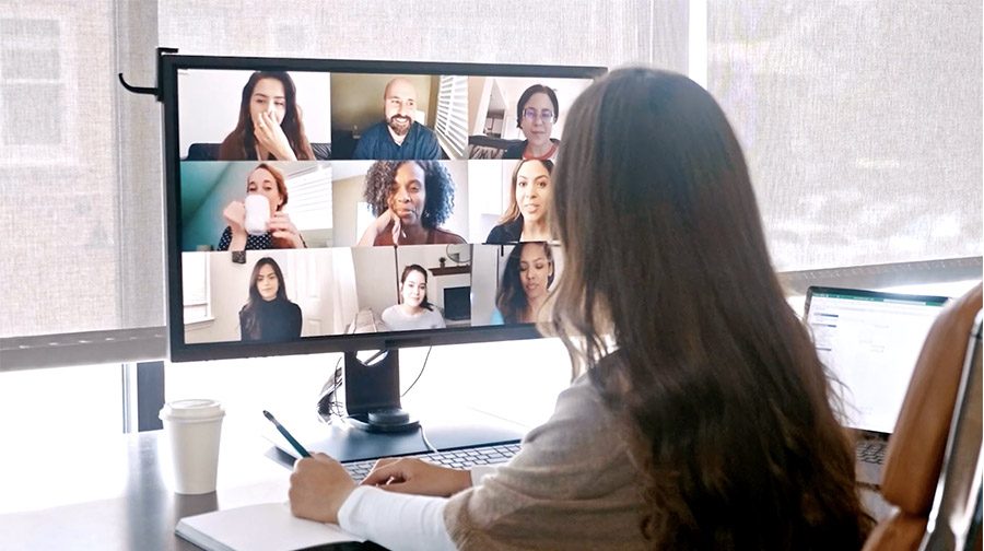 Person Looking at Computer Monitor with Different People on Screen