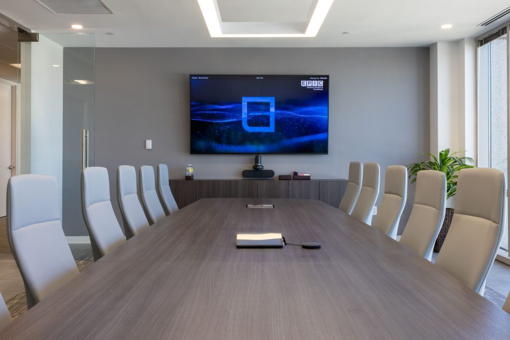 office meeting room with table, chairs, and large TV on wall