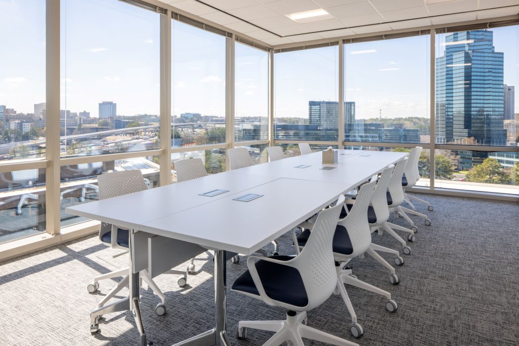 corner office meeting room with table and chairs overlooking city