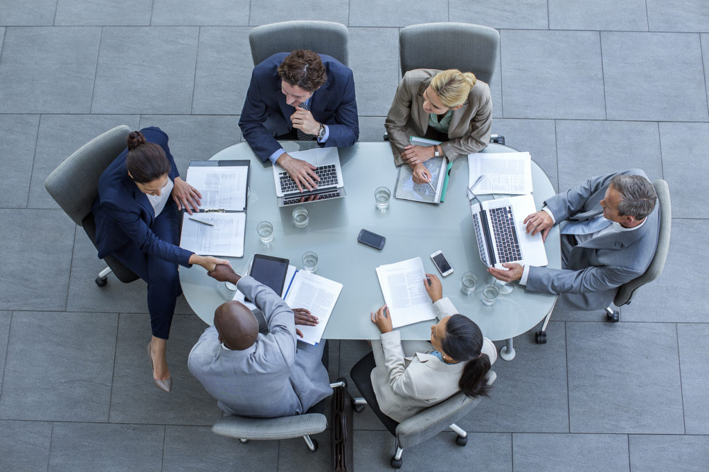 Businesspeople shaking hands at conference table