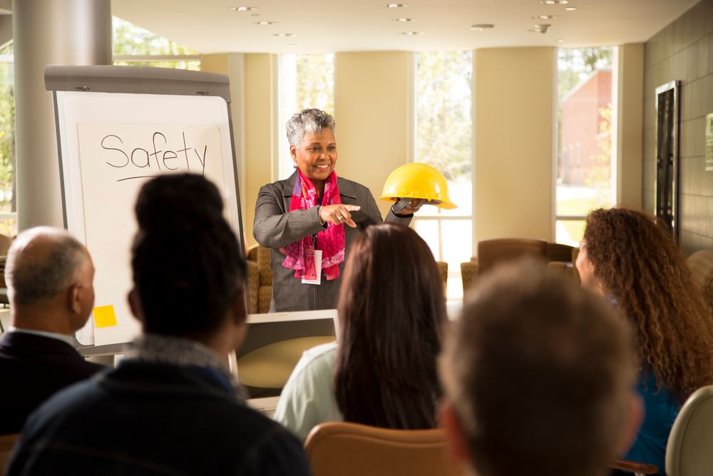 Women reviewing workforce safety training with a group of staff.