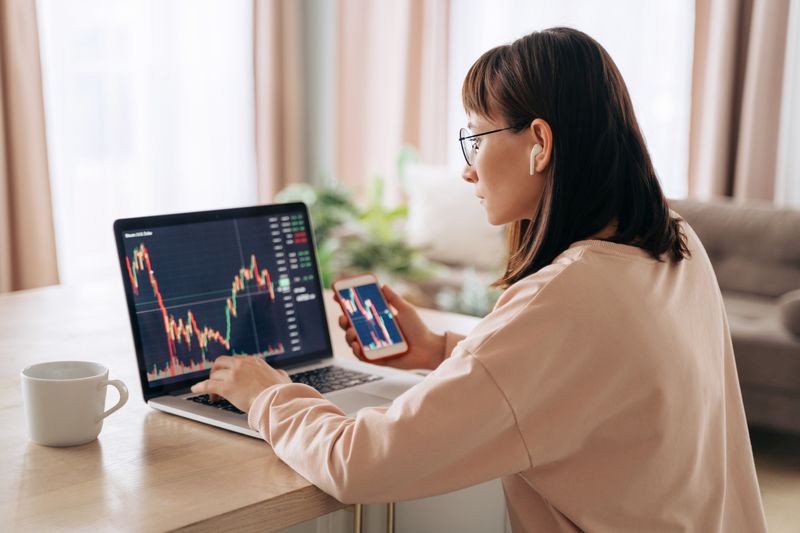 Woman reviewing data charts on laptop.