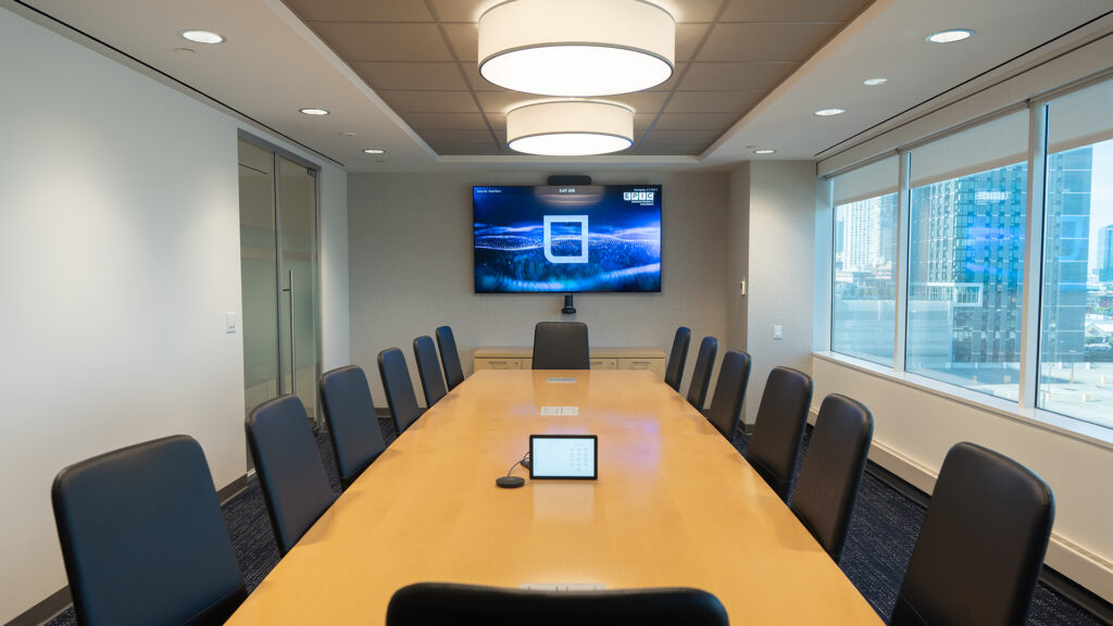 EPIC New Jersey City office meeting room with table, chairs, and large TV