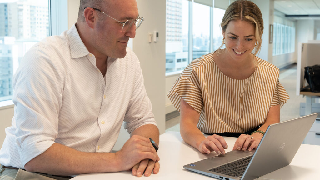 two people looking at a laptop