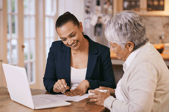 Smiling woman reviewing document with elderly woman