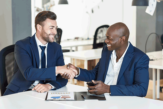 two businessmen smiling and shaking hands