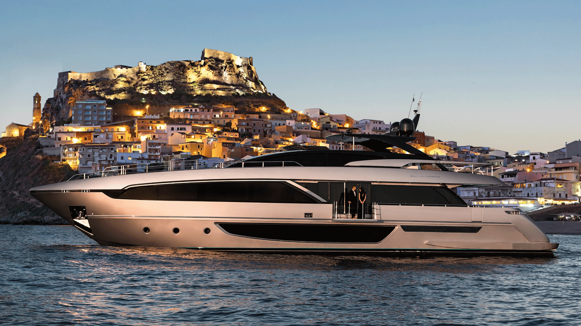 yacht near mountain town at sunset