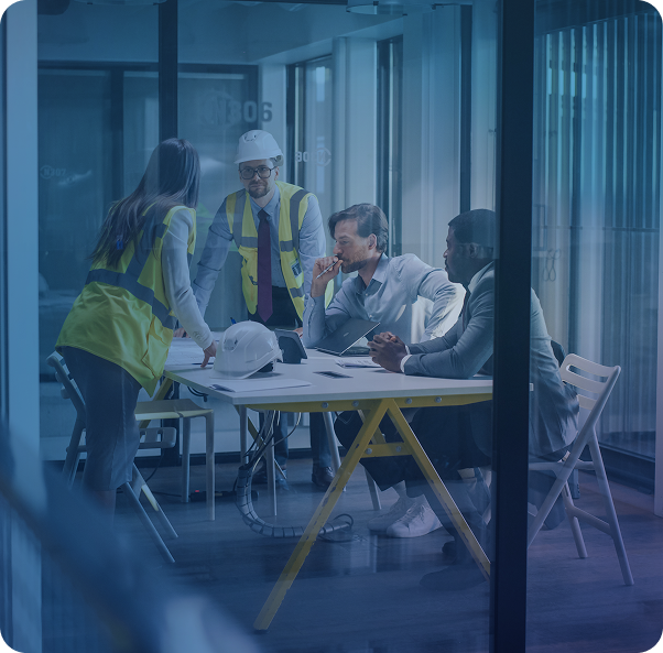 construction workers in meeting with business people