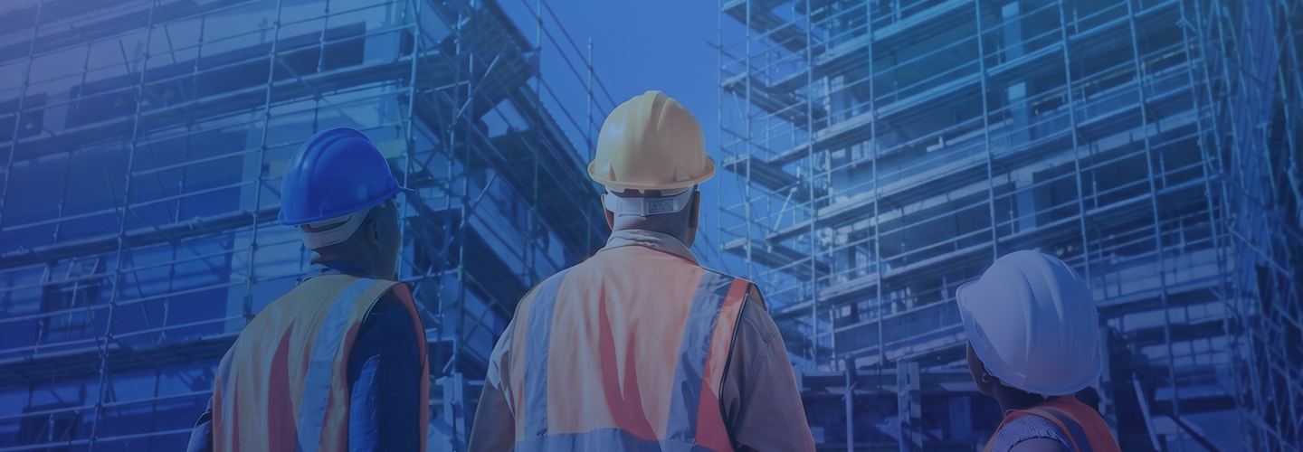 workers in safety wear looking up at building construction
