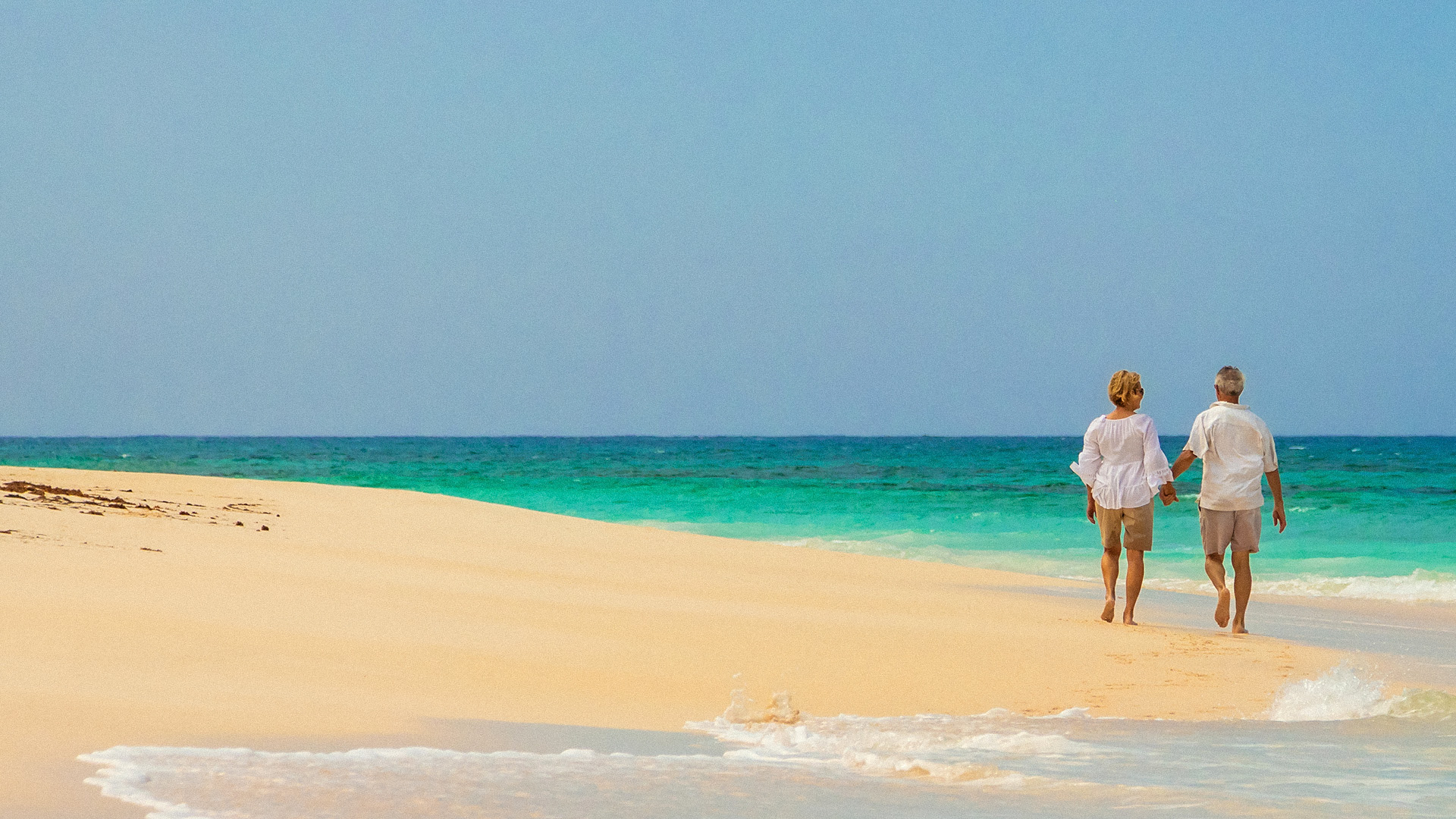 older couple walking on beach