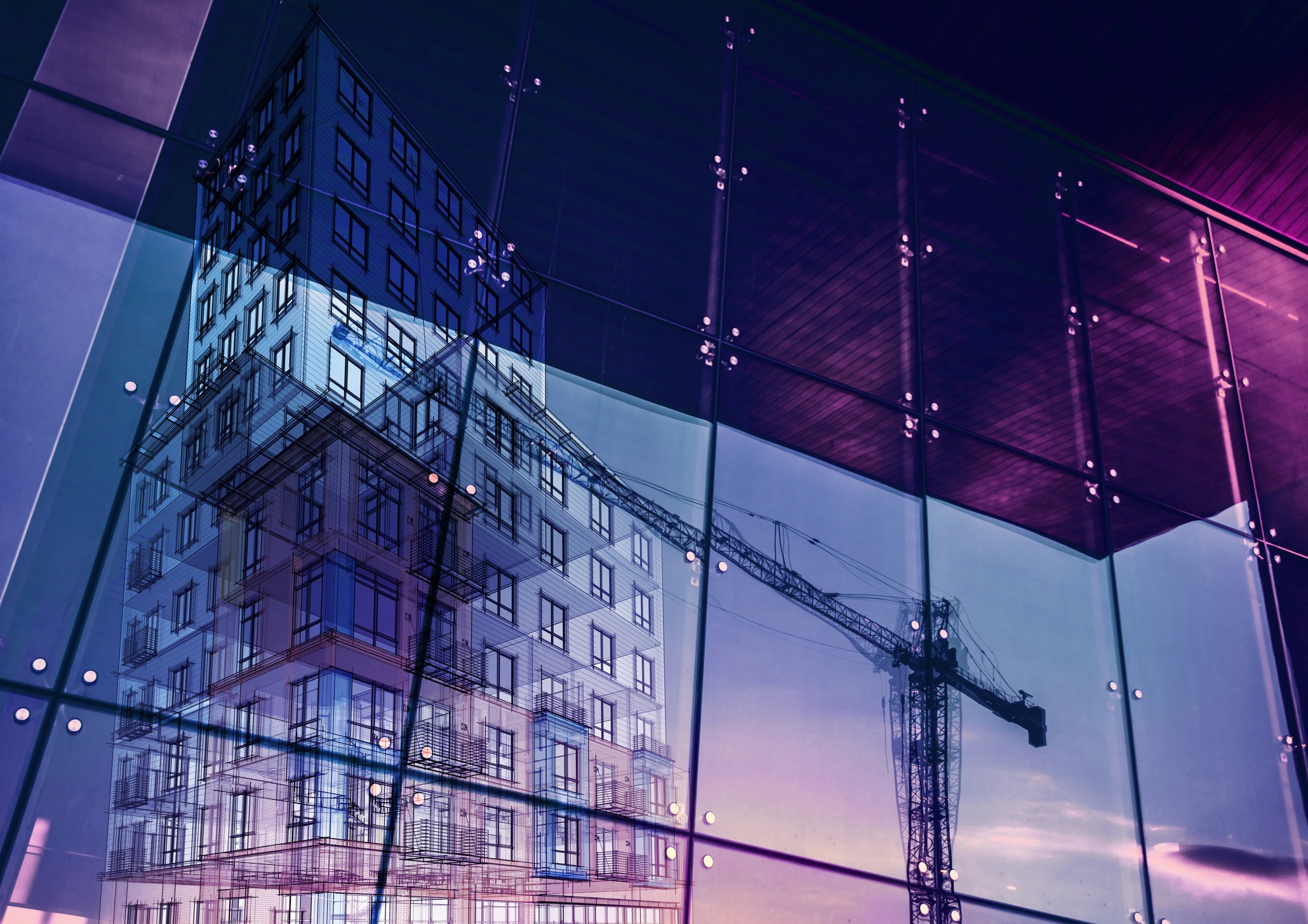 construction crane and building reflected in wall of glass