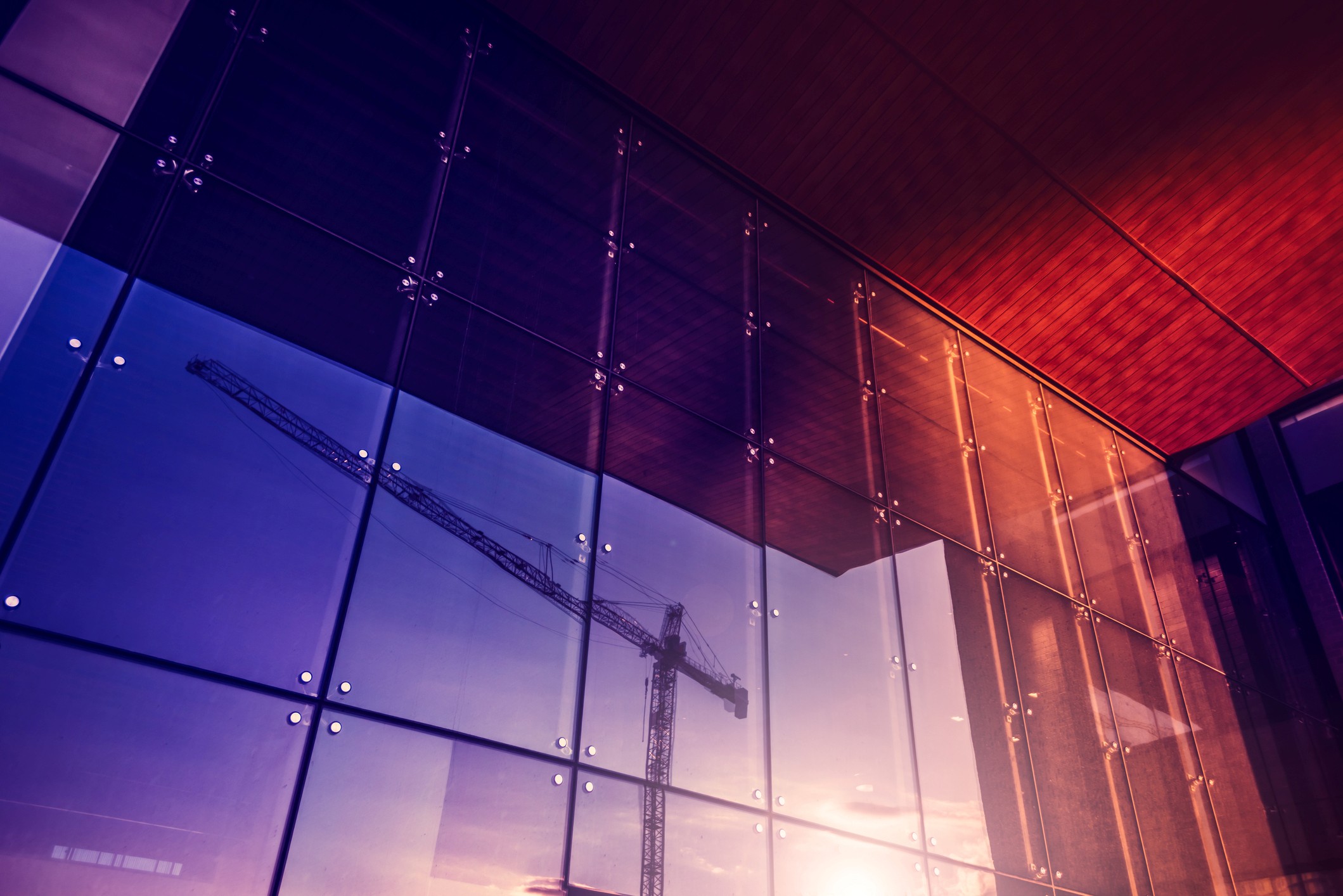 crane reflected in wall of glass
