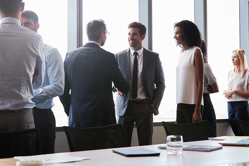 group of business professionals standing in meeting room