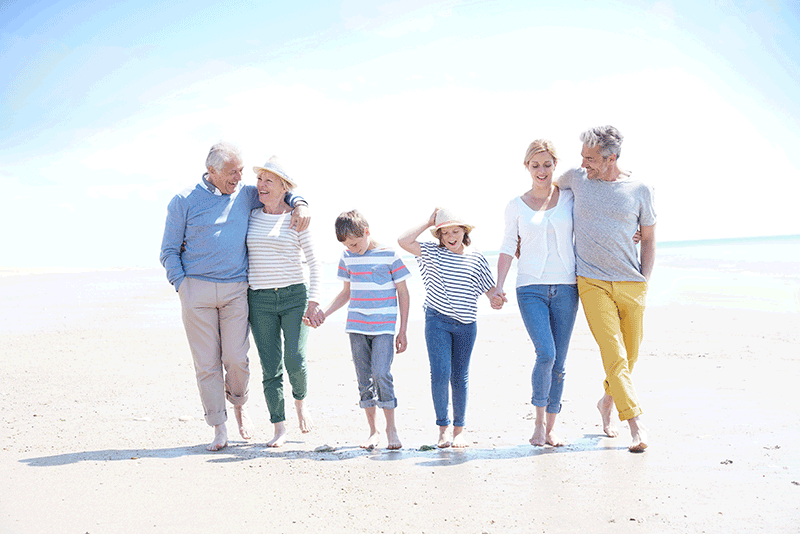 three generations walking on beach