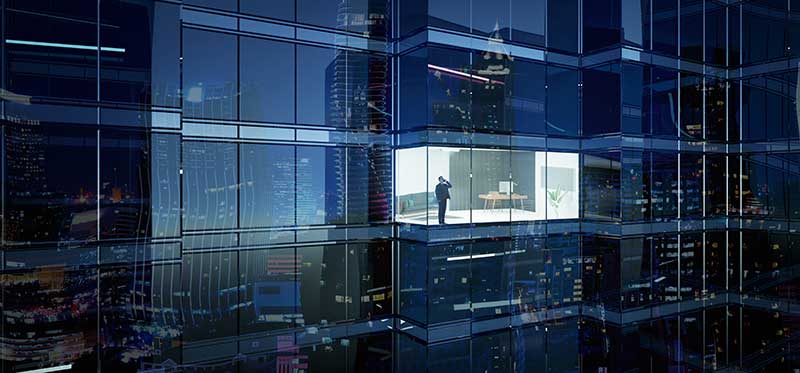 man in lit up window in skyscraper at night