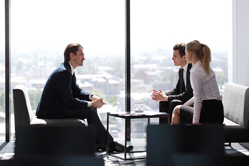 business professionals talking in front of window