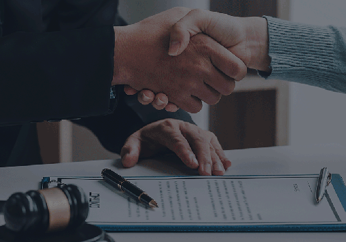 two people shaking hands over document