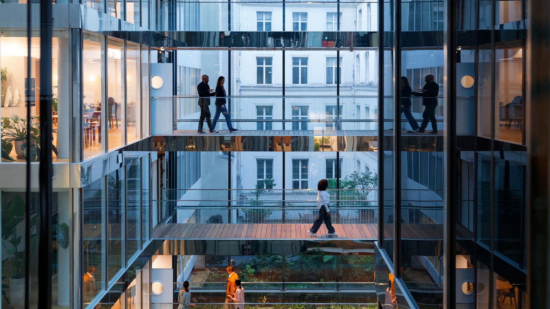 people on walkways in see-through glass building